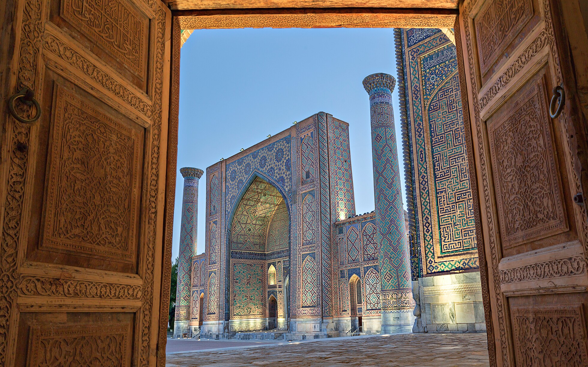 Panoramic view of the ancient Silk Road in Central Asia, showcasing snow-capped mountains, historical caravan routes, and traditional architectural landmarks of the region